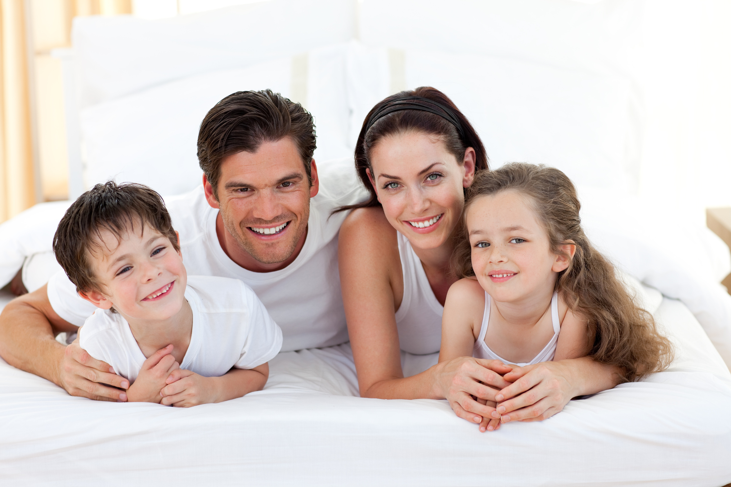 Реклама мамы папы. Счастливая семья. Семья двое детей. Семья на кровати. Семья улыбка.