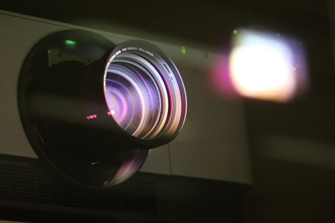 Lente de um projetor de cinema a funcionar no escuro